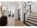 Entryway with staircase and view of the living room, showcasing hardwood floors at 6925 Colfax Ave, Cumming, GA 30040