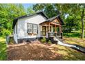 View of the front exterior displaying charming curb appeal, a covered porch, and well-maintained landscaping at 958 Crew Sw St, Atlanta, GA 30315