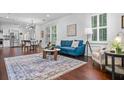 Open-concept living space featuring hardwood floors, neutral tones, and ample natural light from shuttered windows at 958 Crew Sw St, Atlanta, GA 30315