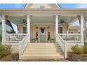 Charming home with a welcoming porch, white railings, and light stone steps leading to the entrance at 11190 Serenbe Ln, Chattahoochee Hills, GA 30268