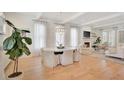 Open-concept living and dining area with hardwood floors and elegant lighting fixture at 11190 Serenbe Ln, Chattahoochee Hills, GA 30268