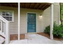 Close-up of the home's entrance featuring a teal storm door, siding, and outdoor lighting at 602 Country Park Se Dr, Smyrna, GA 30080