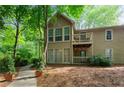Beautiful exterior view of a home featuring balconies and surrounded by lush, mature trees at 602 Country Park Se Dr, Smyrna, GA 30080