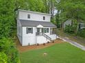 Beautifully landscaped two-story home featuring white siding, black railings, and a lush green lawn at 1080 Westmont Sw Rd, Atlanta, GA 30311