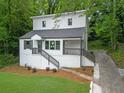 Beautifully landscaped two-story home featuring white siding, black railings, and a lush green lawn at 1080 Westmont Sw Rd, Atlanta, GA 30311