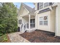 Inviting front entrance featuring a charming porch, decorative wreath, and beautiful stone accents around the door at 4835 Liberty Rd, Villa Rica, GA 30180