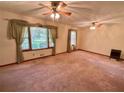 Spacious living room featuring carpeting, large windows, and unique ceiling fans at 5760 Brenda Sw Dr, Mableton, GA 30126