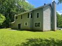 View of the backyard, featuring a large grassy area and mature trees at 6848 Timberhead Way, Lithonia, GA 30058