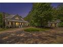 Beautiful farmhouse-style home with a circular driveway and lush landscaping, including a second building with a matching design at 8901 Watkins Mill Rd, Winston, GA 30187