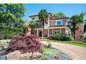 Charming two-story home featuring a tile roof, brick accents, palm trees, and mature landscaping at 1216 E Rock Springs Ne Rd, Atlanta, GA 30306