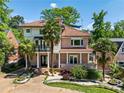 Beautiful two-story home boasts a tile roof, brick accents, manicured landscaping, and palm trees at 1216 E Rock Springs Ne Rd, Atlanta, GA 30306