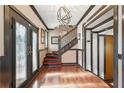Grand foyer boasts dark-trimmed doors, staircase, hardwood floors, and stylish chandelier at 1216 E Rock Springs Ne Rd, Atlanta, GA 30306