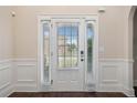Elegant front door with sidelights, decorative trim, and hardwood floors at 1314 Bentley Estates Dr, Dacula, GA 30019