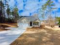 Beautiful exterior shot of a charming single-story home on a sprawling lot surrounded by lush greenery at 5096 Cumberland Ct, Villa Rica, GA 30180