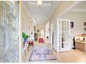 Bright foyer features decorative glass door, neutral walls, wood-look floors, and colorful area rugs at 608 Red Leaf Way, Canton, GA 30114