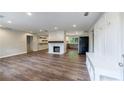 Open-concept living area with wood floors, a stone fireplace, and a view of the kitchen at 1304 Anchor Sw Ter, Atlanta, GA 30311