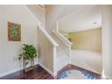Open foyer with wooden floors, staircase with white banister, leading into carpeted living area at 1130 Laurel Cove Dr, Snellville, GA 30078