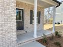 Inviting front porch with brick columns and a view of the landscaped yard at 18 Loth Wages (Lot 18) Rd, Dacula, GA 30019