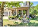 Inviting front porch decorated with potted plants and comfortable seating, perfect for relaxation at 345 Piedmont Cir, Covington, GA 30016