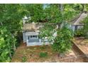 Aerial view showcasing the light gray home surrounded by lush greenery and mature trees at 1939 Dunlap Ave, Atlanta, GA 30344