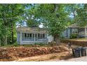 View of a single-story light gray home nestled among mature trees in a residential neighborhood at 1939 Dunlap Ave, Atlanta, GA 30344