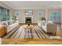 Bright living room with a fireplace, large windows, light walls, and hardwood floors and furniture creating an inviting atmosphere at 2419 Boulder Se Rd, Atlanta, GA 30316