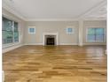 Bright living room with a fireplace, large windows, light walls, crown moulding, and gleaming hardwood floors at 2419 Boulder Se Rd, Atlanta, GA 30316