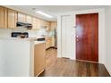 Compact kitchen with wooden cabinetry, stainless steel appliances, and hardwood floors at 199 14Th St # 409, Atlanta, GA 30309