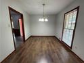 Bright dining room featuring hardwood floors, a modern chandelier, and natural light from large windows at 2184 River Acres Ct, Lithonia, GA 30058