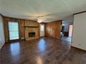 Inviting living room with brick fireplace, wood paneling, and gleaming hardwood floors at 2184 River Acres Ct, Lithonia, GA 30058