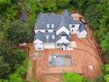 Aerial view of the new home construction with a pool surrounded by lush trees at 388 Londonberry Road, Sandy Springs, GA 30327