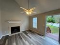 Bright living room boasts vaulted ceilings, fireplace, modern flooring, and open concept floor plan at 4911 Hairston Pl, Stone Mountain, GA 30088