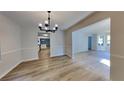 Bright dining area featuring wood-look flooring and a modern chandelier, creating an inviting space at 5368 Knights Lndg, Ellenwood, GA 30294