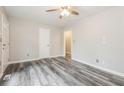 Spacious bedroom featuring neutral paint colors, ceiling fan, and modern gray laminate flooring at 823 Catherine St, Forest Park, GA 30297