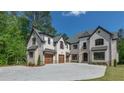 An exterior view showcasing the home's brick facade, multiple garages, and extensive driveway at 10765 Shallowford Rd, Roswell, GA 30075