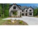 An exterior view of a home with a white facade, black trim, and meticulously landscaped front yard at 10765 Shallowford Rd, Roswell, GA 30075