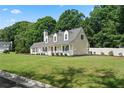 Spacious home featuring a lush green lawn, mature trees, and a charming covered front porch at 710 Crab Orchard Ct, Roswell, GA 30076