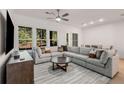 Spacious living room with a large sectional sofa, a ceiling fan, and plenty of natural light from the windows at 1070 Harper Dr, Alpharetta, GA 30076