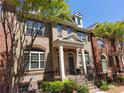 Charming townhome featuring a brick facade, dormer windows and landscaped front yard at 10856 Ellicot Way, Alpharetta, GA 30022