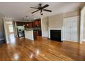 Spacious living area featuring hardwood floors, a fireplace, and an open layout to the kitchen at 10856 Ellicot Way, Alpharetta, GA 30022