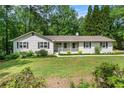 Well-maintained single-story home with a charming front porch and fresh landscaping, inviting curb appeal at 1824 Mcclung Rd, Hiram, GA 30141