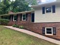 Close-up of the home's front, highlighting the brickwork, siding, and inviting entryway with manicured landscaping at 215 N Etowah Ct, Canton, GA 30114