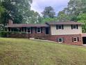 Traditional two-story home featuring a brick and vinyl facade, dark shutters, and mature trees at 215 N Etowah Ct, Canton, GA 30114