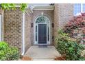 Close-up of the front door featuring an arched window, sidelights, and classic brick surround at 3314 Dilmus Dr, Powder Springs, GA 30127