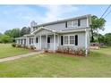 Two-story home featuring a well-manicured lawn, mature trees, and charming architectural details at 100 Fairview Dr, Stockbridge, GA 30281