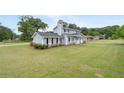 Well-maintained two-story home with a spacious lawn, mature trees, and classic architectural design at 100 Fairview Dr, Stockbridge, GA 30281