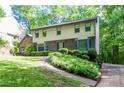 Attractive two-story home with well-maintained lawn, complemented by trees and shrubbery in a serene setting at 4953 Mcpherson Ne Dr, Roswell, GA 30075