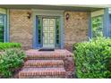 Elegant front entrance featuring brick steps, a decorative door, and manicured shrubs for added curb appeal at 4953 Mcpherson Ne Dr, Roswell, GA 30075