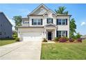 Charming two-story home with a white brick facade, attached garage, manicured lawn, and beautiful landscaping at 7455 Easton Valley Ln, Cumming, GA 30028