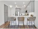 Stylish kitchen with gray cabinets, stainless appliances, a breakfast bar, and three rattan bar stools at 1055 Piedmont Ne Ave # 409, Atlanta, GA 30309